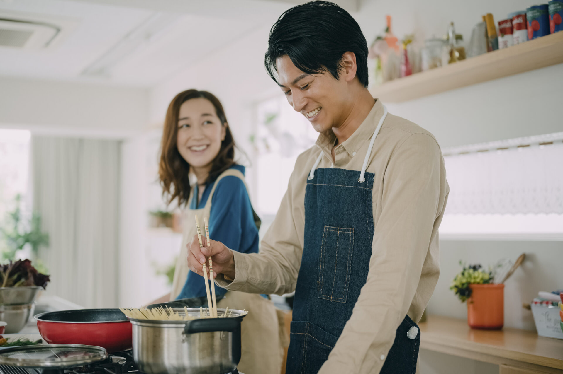 コンロを使って調理するカップル